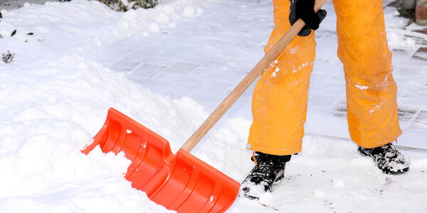 Person beim Schneeschaufeln, Symbolbild